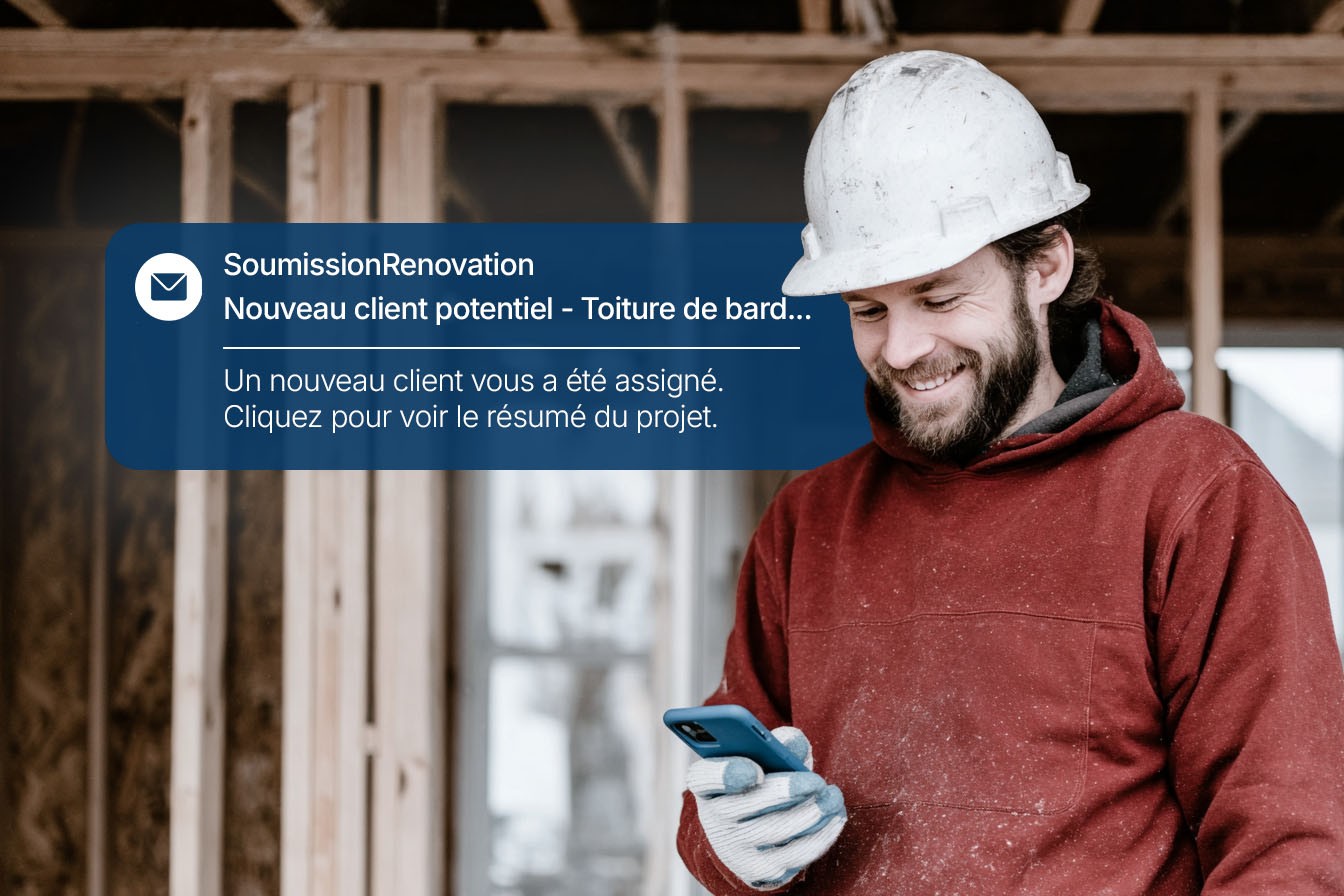 Construction worker wearing a white hard hat and red hoodie smiling while looking at his phone at a construction site, with a notification from SoumissionRenovation about a new assigned client project.